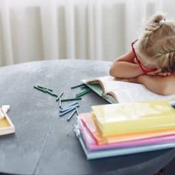 Little girl taking a nap at her desk.