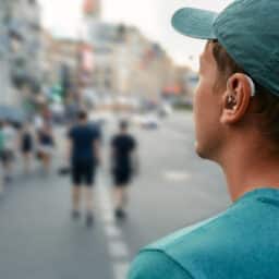 Man wearing hearing aid in the city.