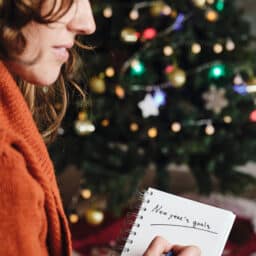 Woman writing a list of new year's resolutions.