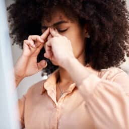 Woman rubs bridge of her nose