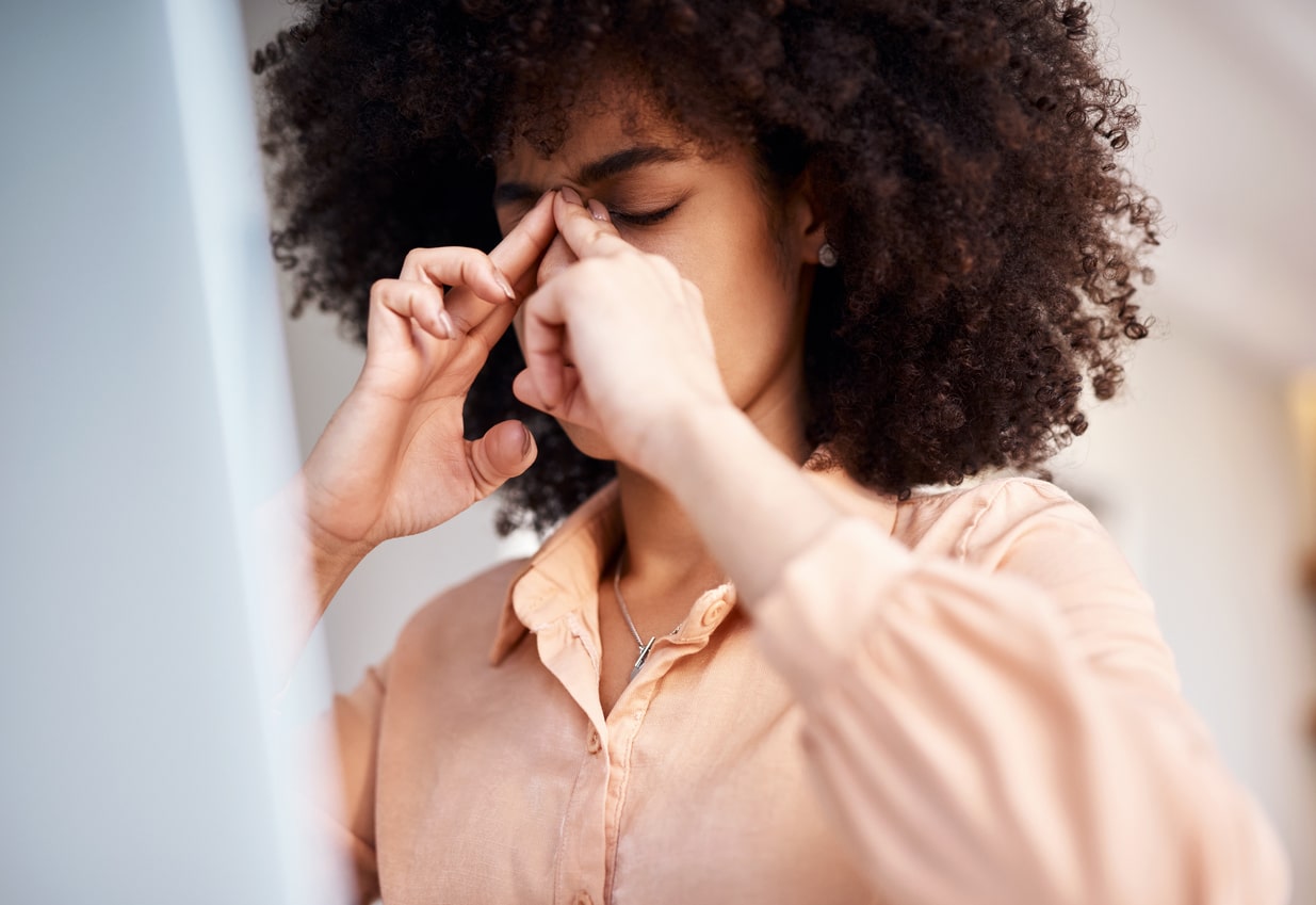 Woman rubs bridge of her nose