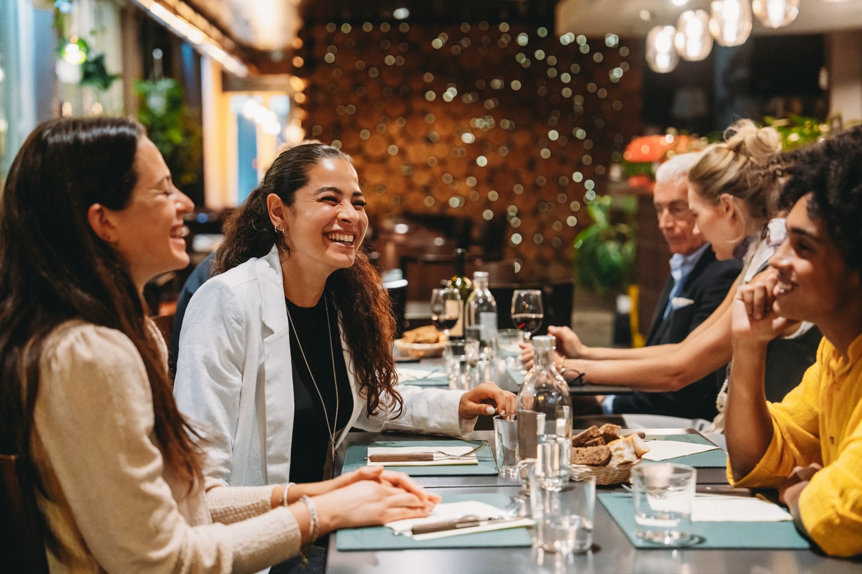 Friends laughing and enjoying dinner together