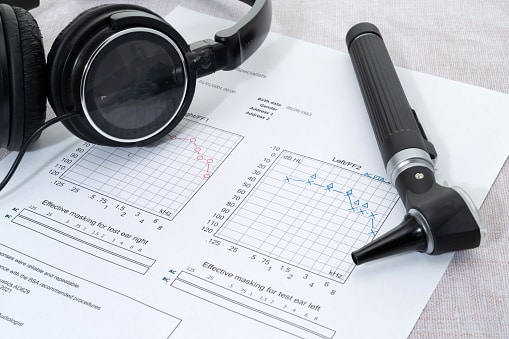 Audiogram paper with headphones and an otoscope.